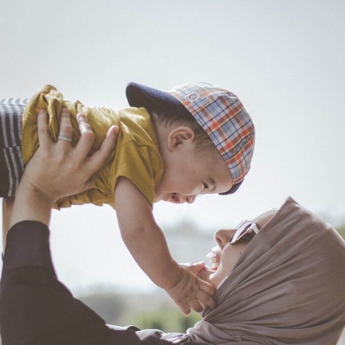 woman holding boy during daytime